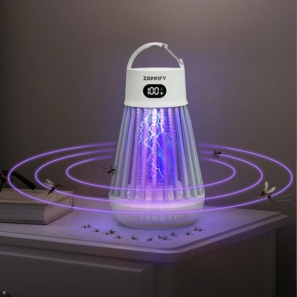 White portable insect zapper glowing violet on a bedside table